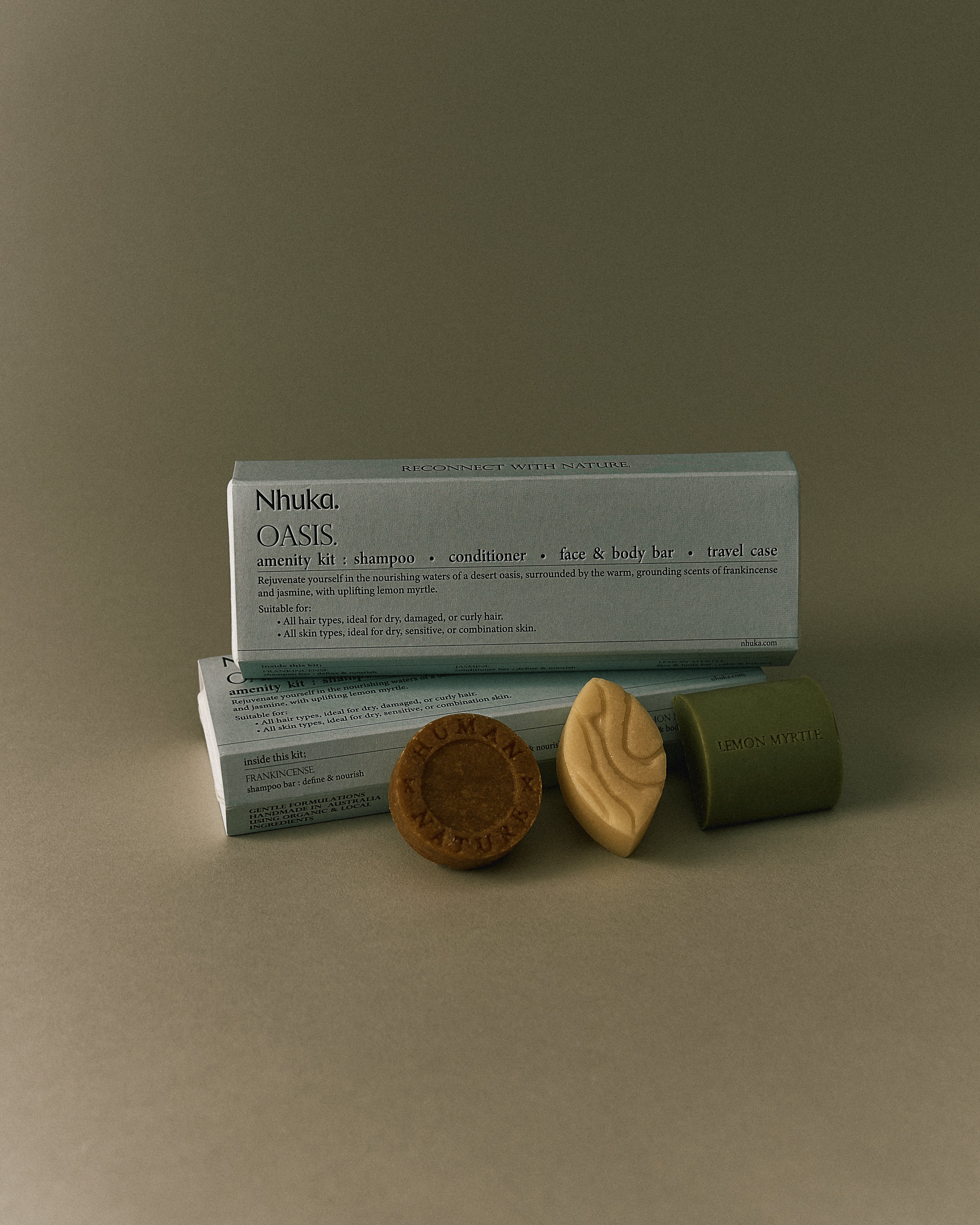 Nhuka Oasis Amenity Kit with shampoo, conditioner, face & body bar, and packaging. Warm tones with frankincense and jasmine. Ideal for dry, curly hair and normal to sensitive skin.