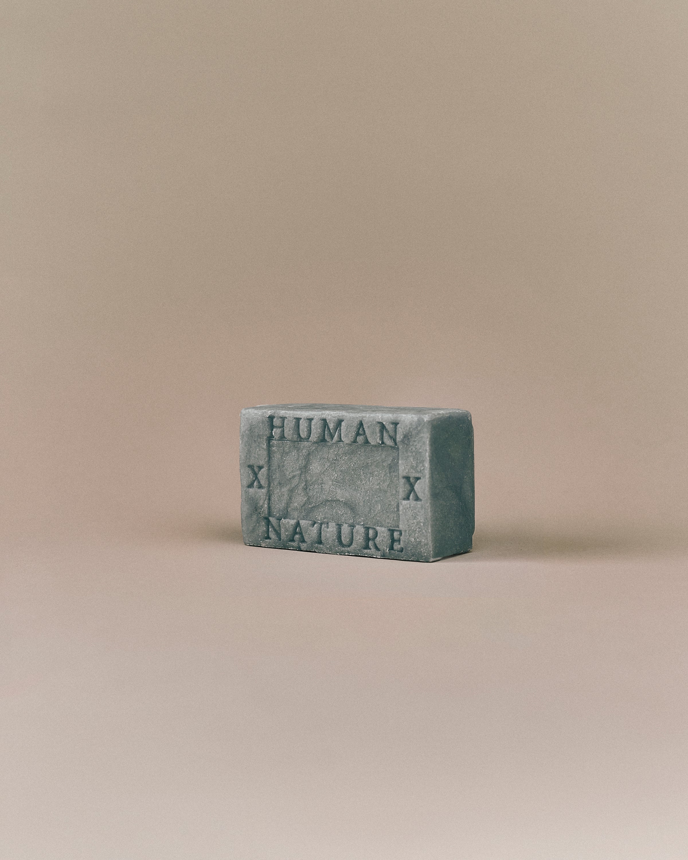 Nhuka Ocean One Bar angled view with Human x Nature emboss. Handmade in Australia, pH-balanced, sulfate-free, silicone-free, and organic. Features cooling menthol and a refreshing scent for hair, face, and body.