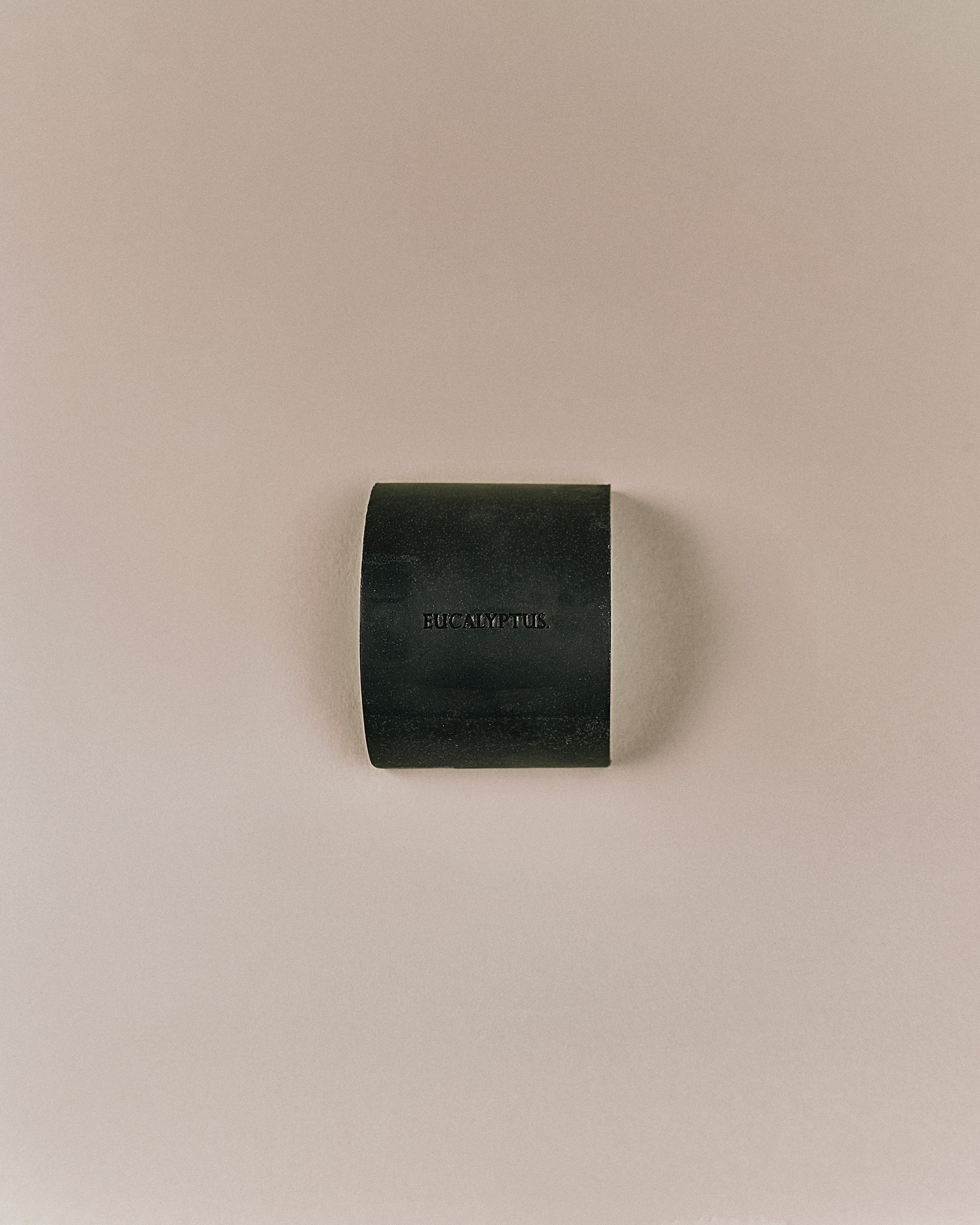 Top view of Nhuka organic eucalyptus soap bar, embossed with product name. Solid, plastic-free cleanser for face and body