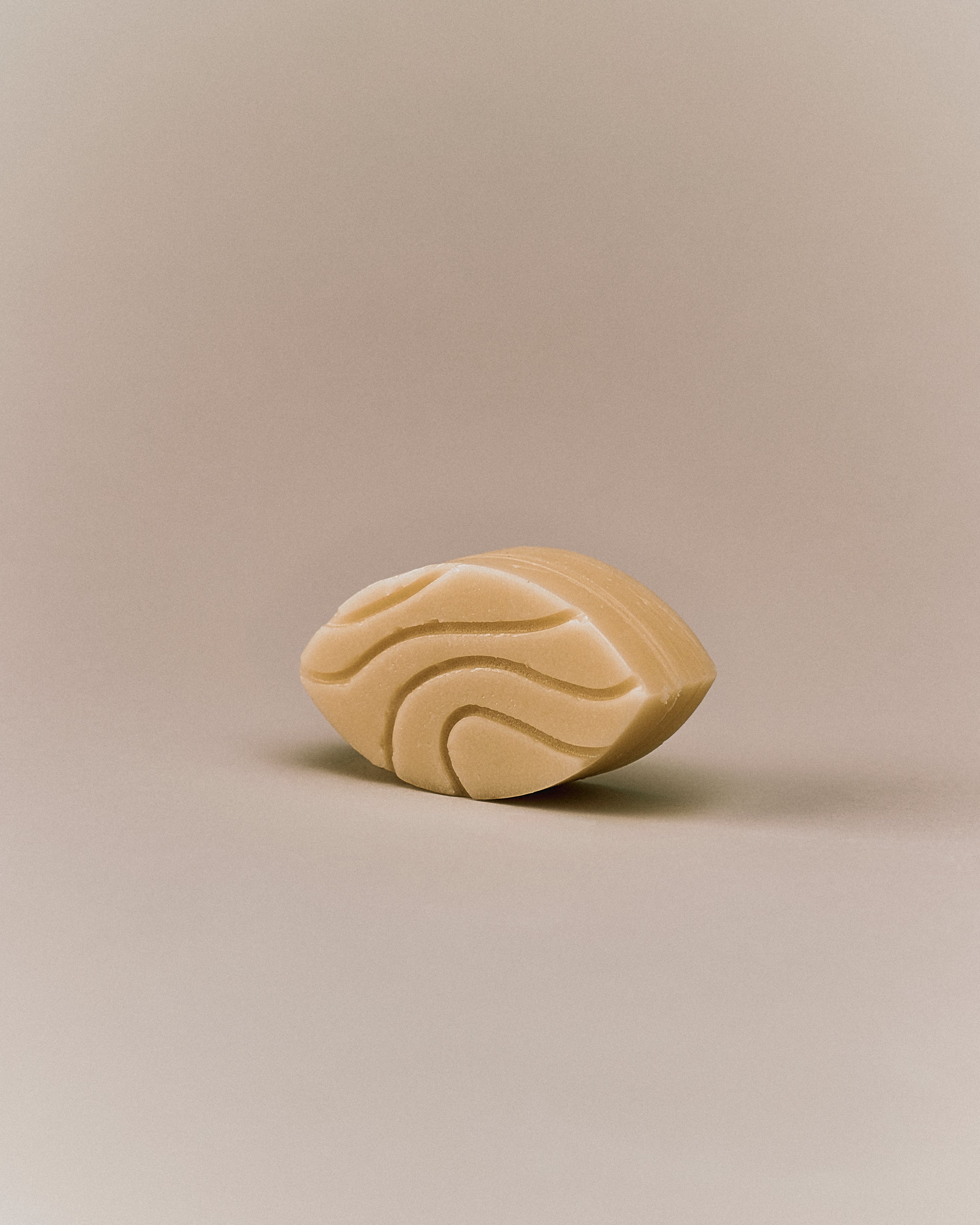 Nhuka organic jasmine conditioner bar shown at an angle with wave-etched design. Handmade in Australia, silicone-free, pH-balanced, and organic — ideal for curly or damaged hair.