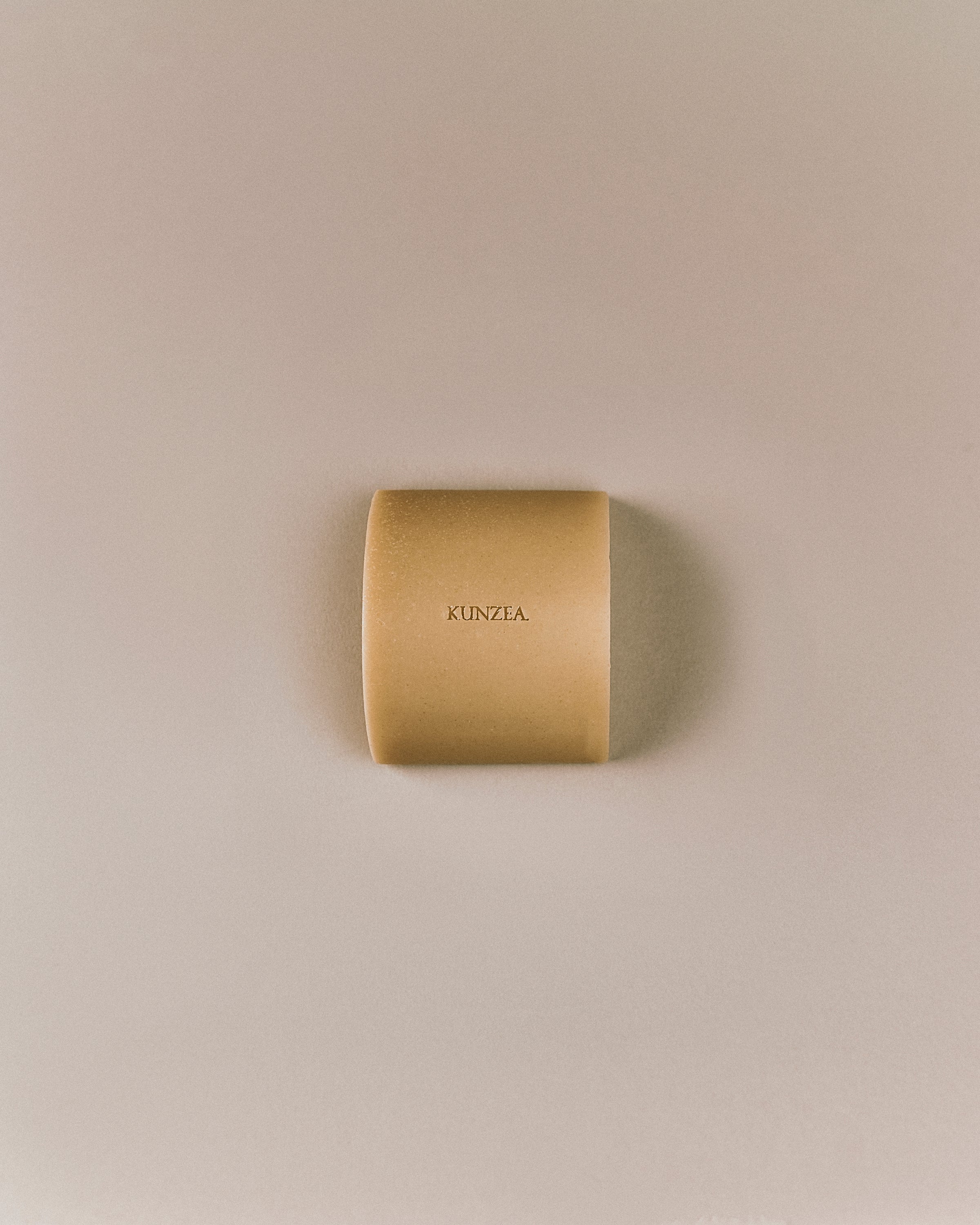 Top-down view of Nhuka organic kunzea face and body soap bar, embossed with product name. Natural soap for daily skin care and gentle exfoliation.