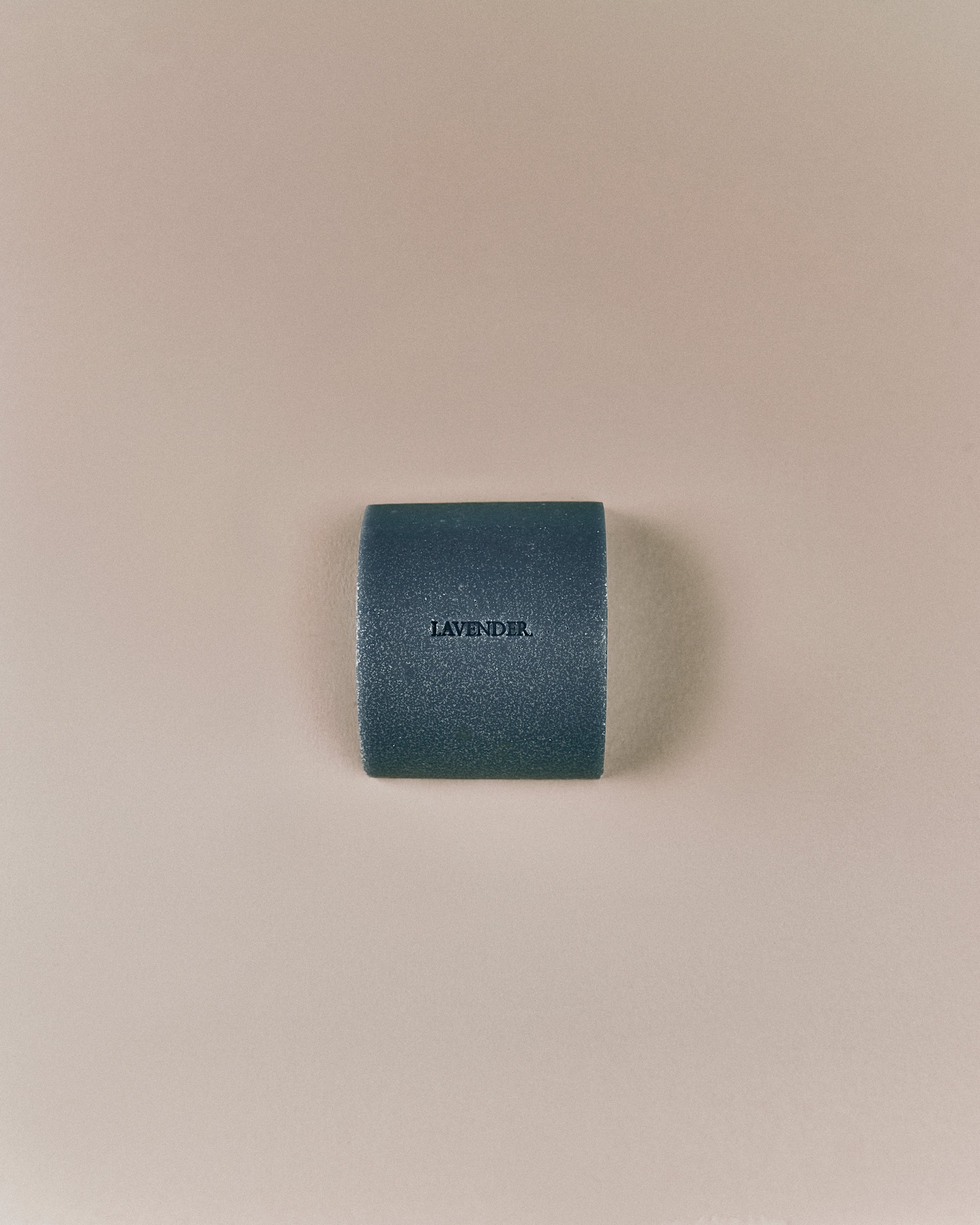 Top-down view of Nhuka organic lavender face and body soap bar, embossed with product name. Solid soap for daily skin care and hydration.
