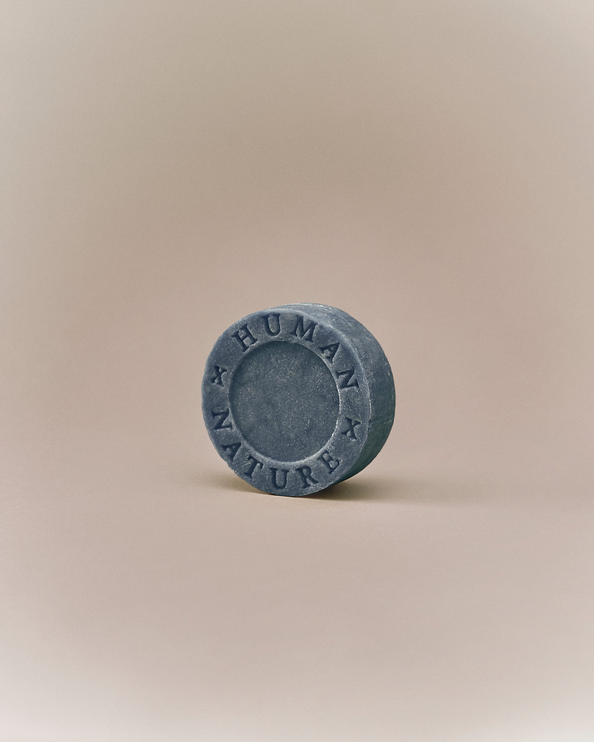 Nhuka organic lavender shampoo bar shown at an angle with Human x Nature emboss. Handmade in Australia, sulfate-free, silicone-free, pH-balanced for dry or frizzy hair.