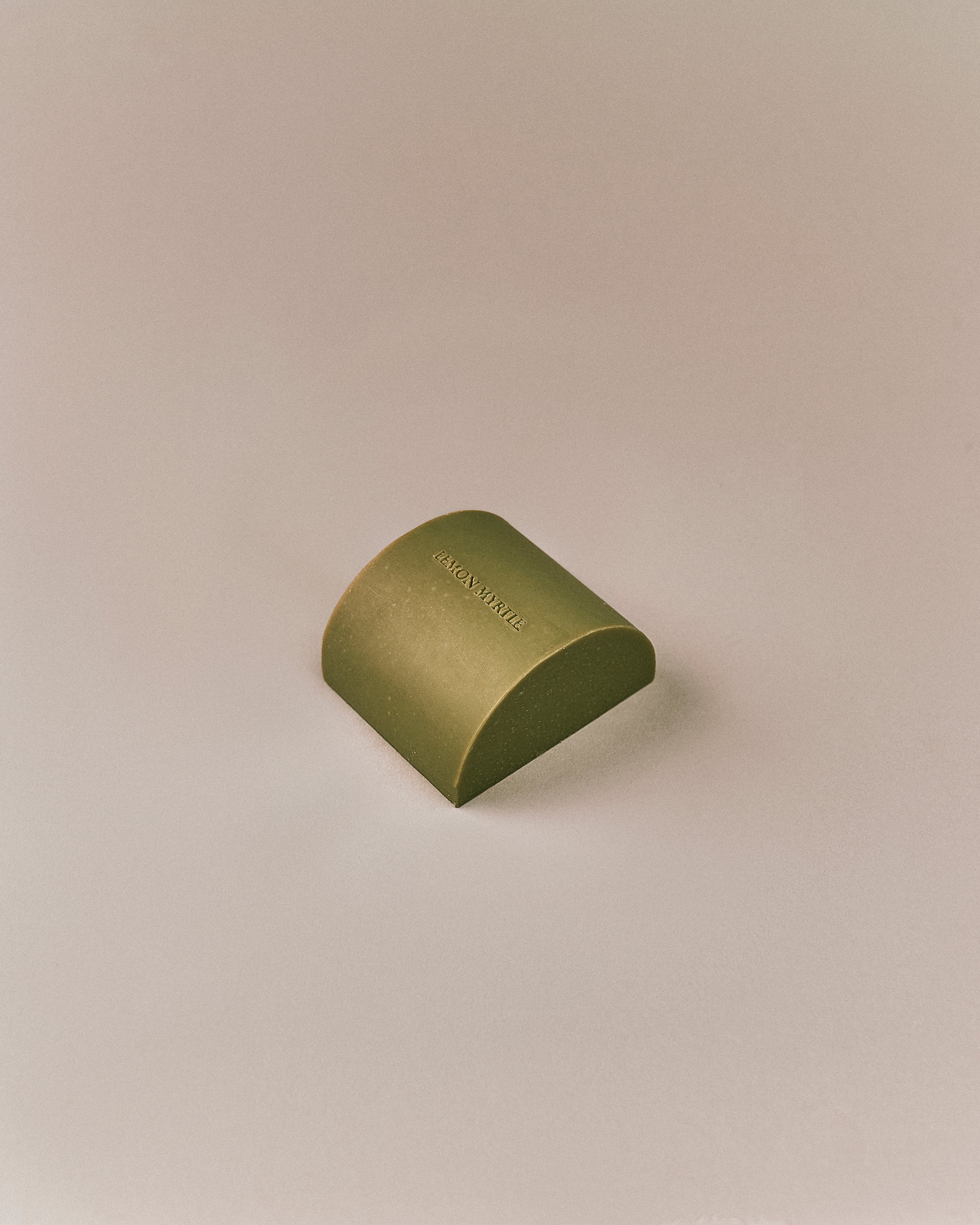 Nhuka organic lemon myrtle soap bar shown at an angle. Solid soap infused with lemon myrtle oil and Brazilian gold clay to soothe and rebalance skin.