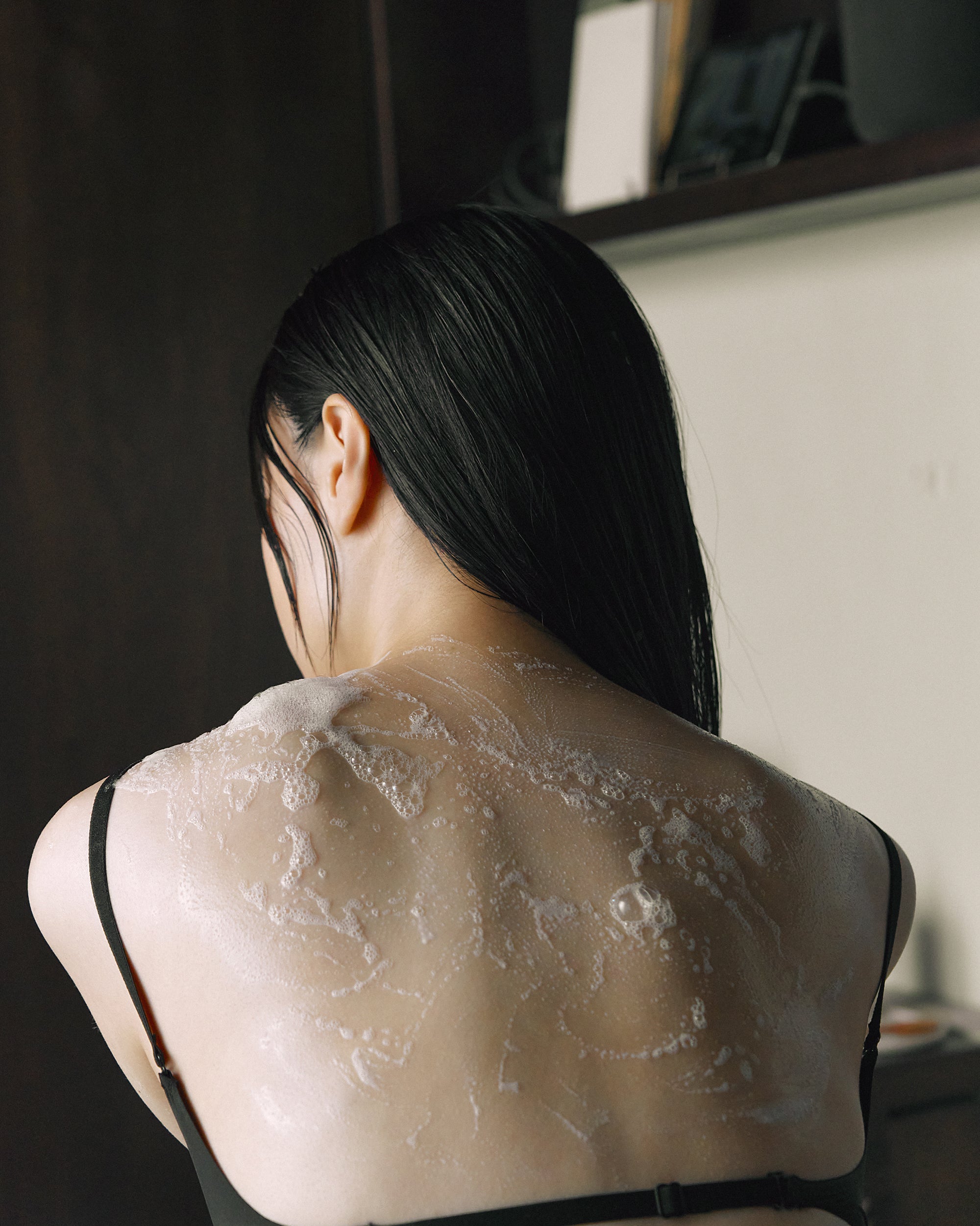 Lathered back and shoulders of model after using Nhuka organic soap. Creamy foam for gentle daily skin care.