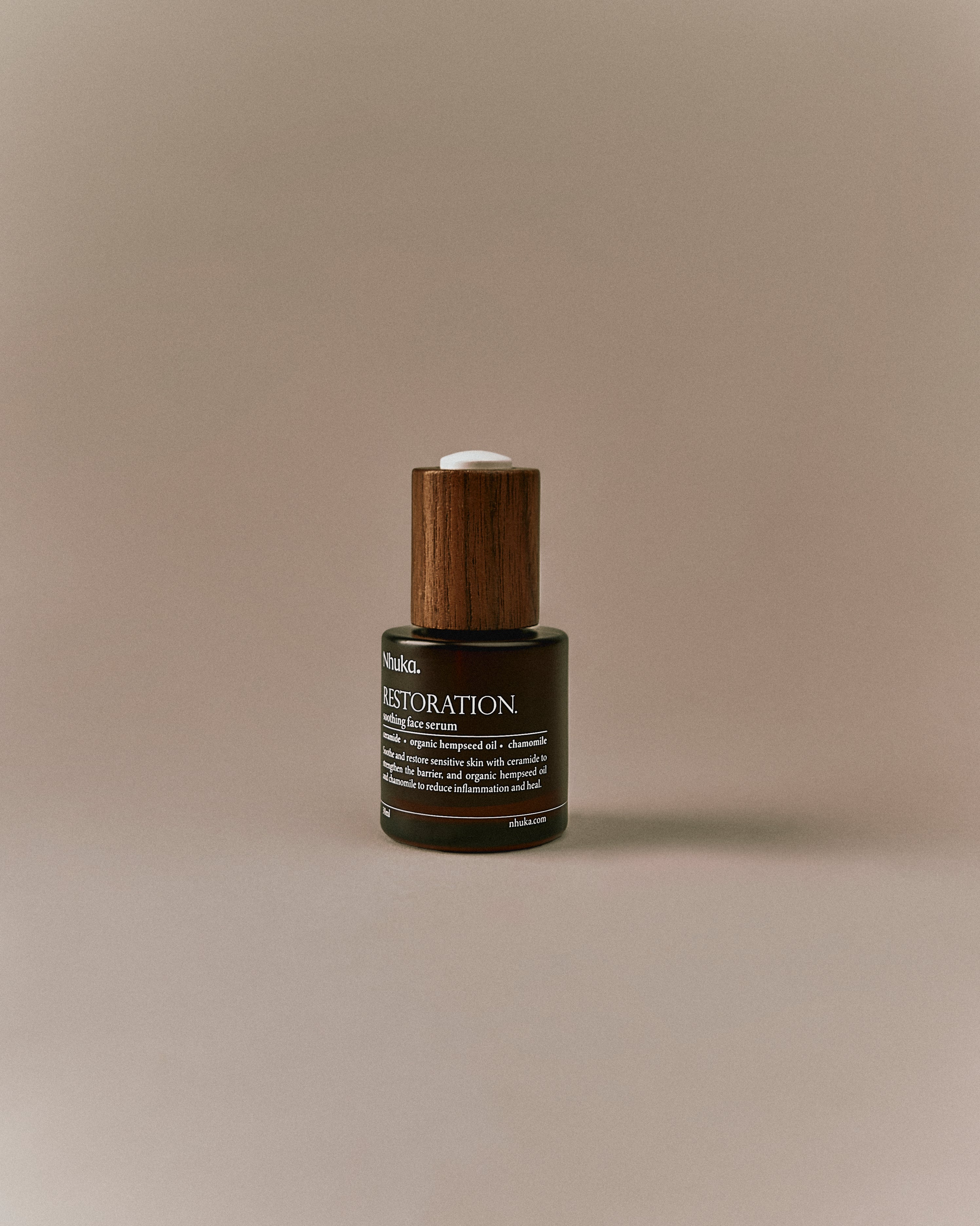 Nhuka Restoration Face Serum shown at an angle. A lightweight serum designed to calm sensitive skin, restore balance, and support a healthy skin barrier with ceramides and organic botanicals.
