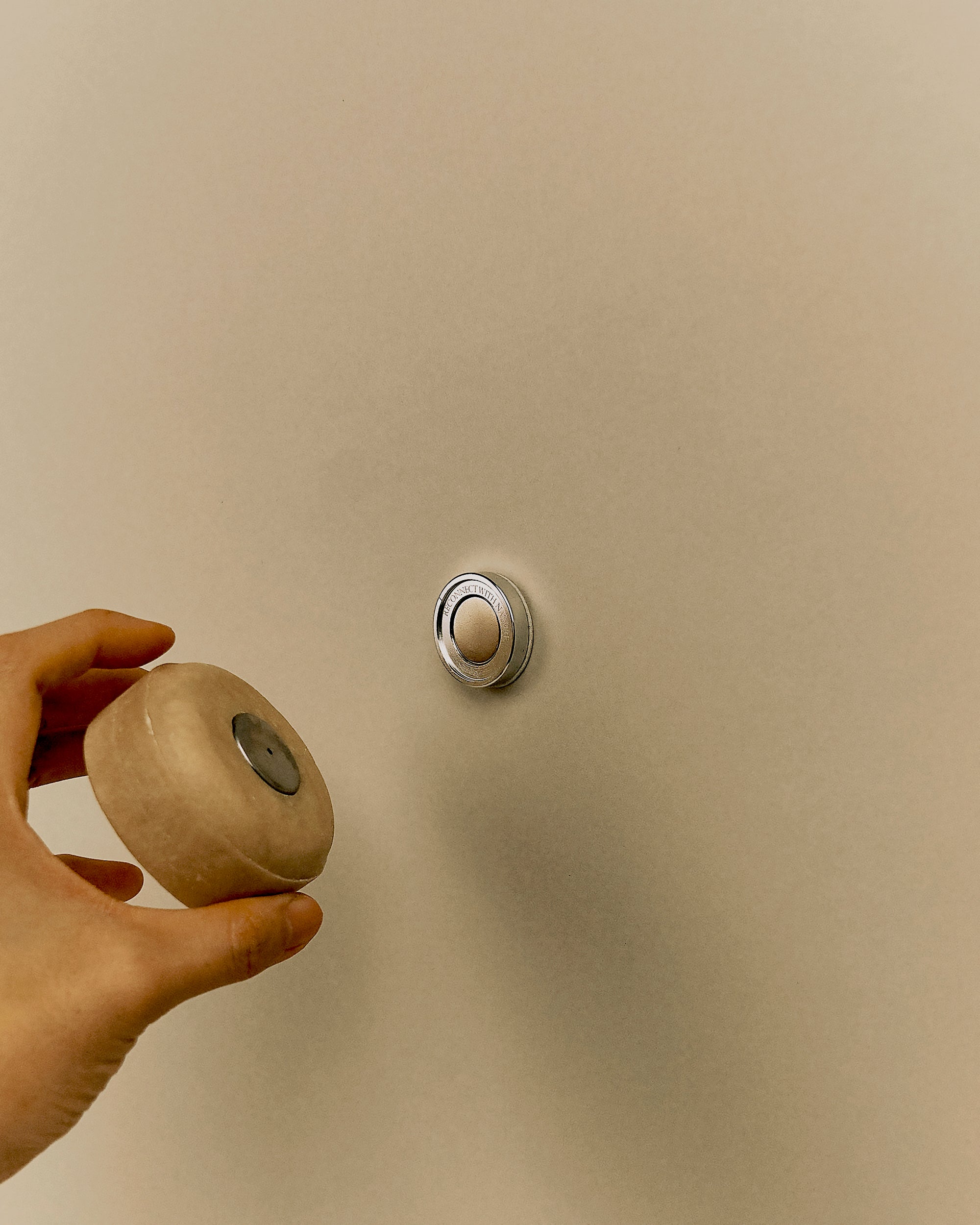 huka Stem magnetic bar holder in use with a round shampoo bar. Stainless steel cap embedded in the soap connects to wall-mounted base to elevate and dry the bar.