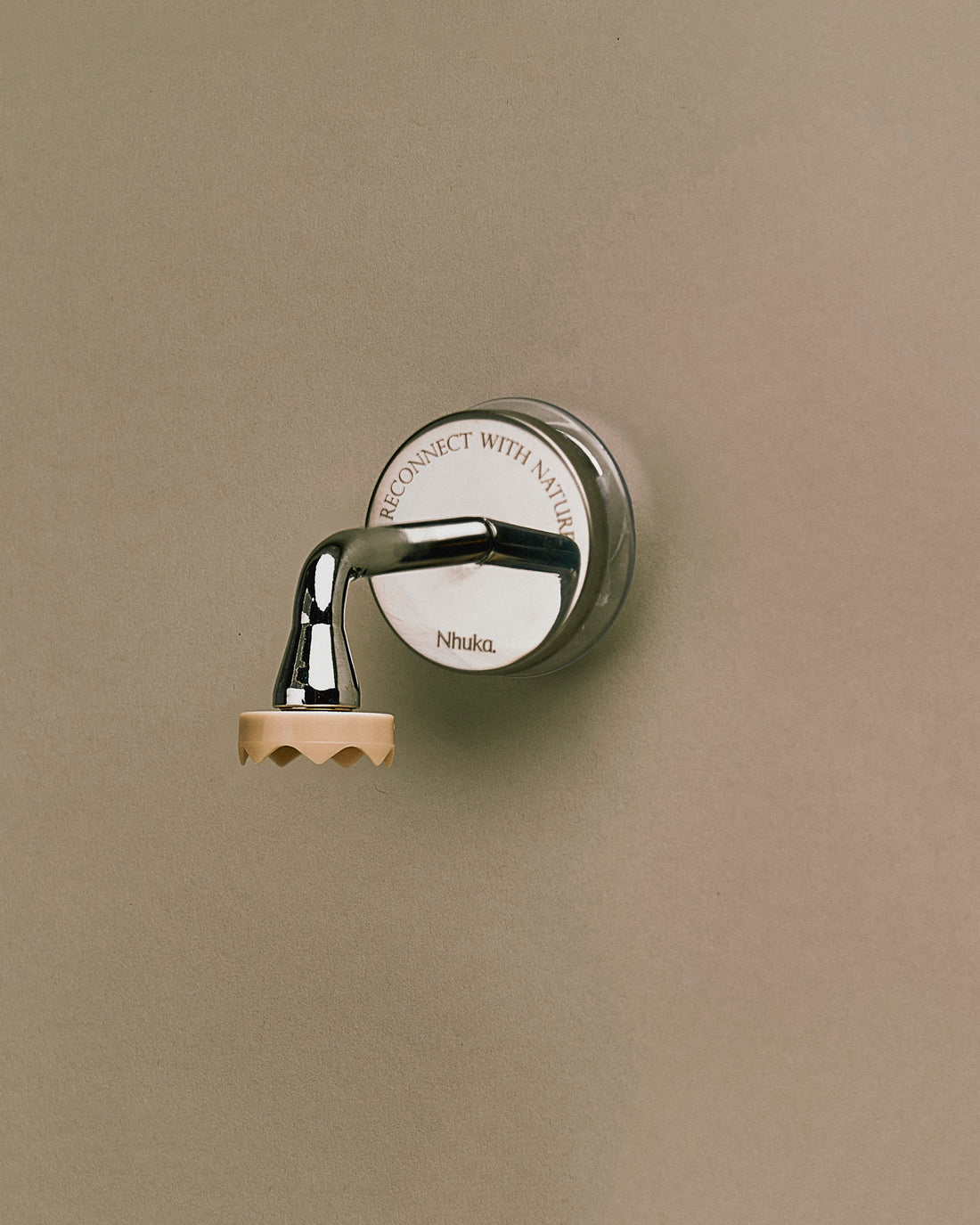 Nhuka Branch magnetic bar holder mounted on a smooth surface. Minimalist and functional design with a chrome hook and engraved backplate. Holds bars suspended to keep them dry and ready for use.