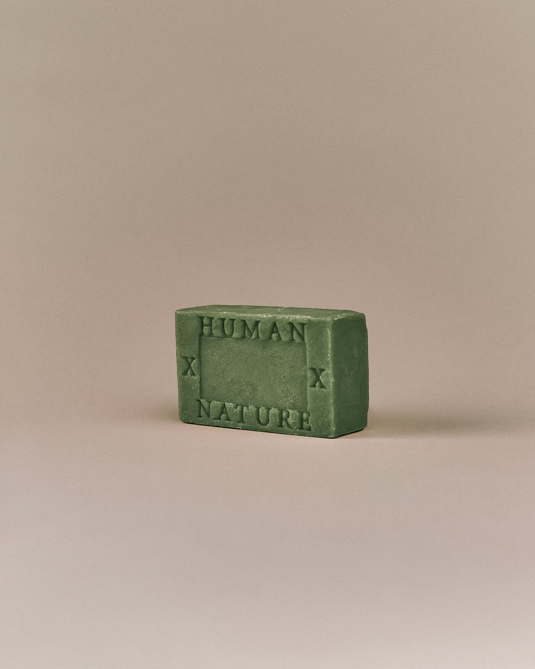 Nhuka Myrtle Forest One Bar shown at an angle with Human x Nature emboss. Handmade in Australia, pH-balanced, sulfate-free, silicone-free, and organic. Fresh green scent with lemon myrtle and honey myrtle. No exfoliant. Designed for hair, face, and body.