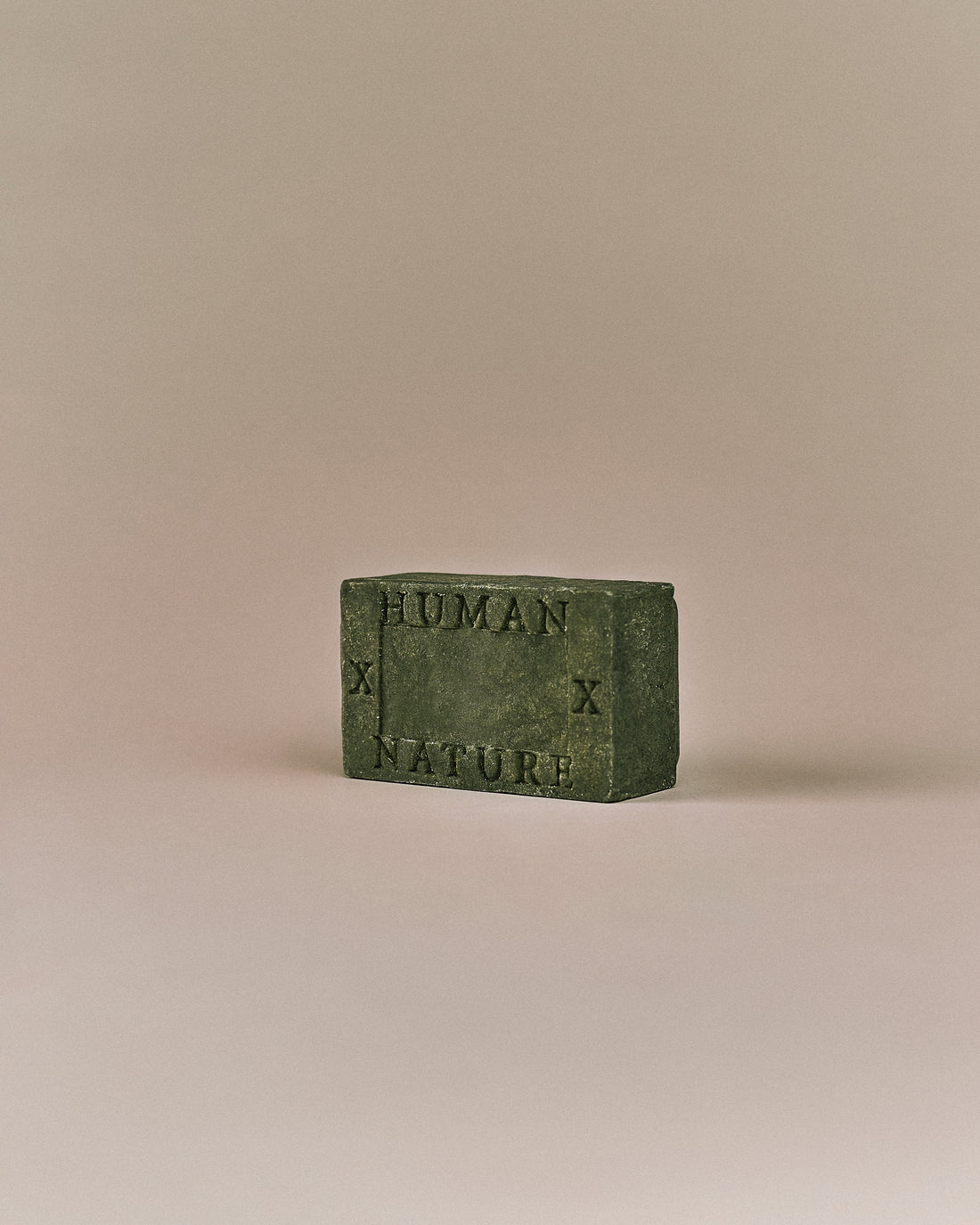 Nhuka Oak Moss One Bar shown at an angle with Human x Nature emboss. Handmade in Australia, pH-balanced, sulfate-free, silicone-free, and organic. Earthy scent with gentle cleansing for hair, face, and body.