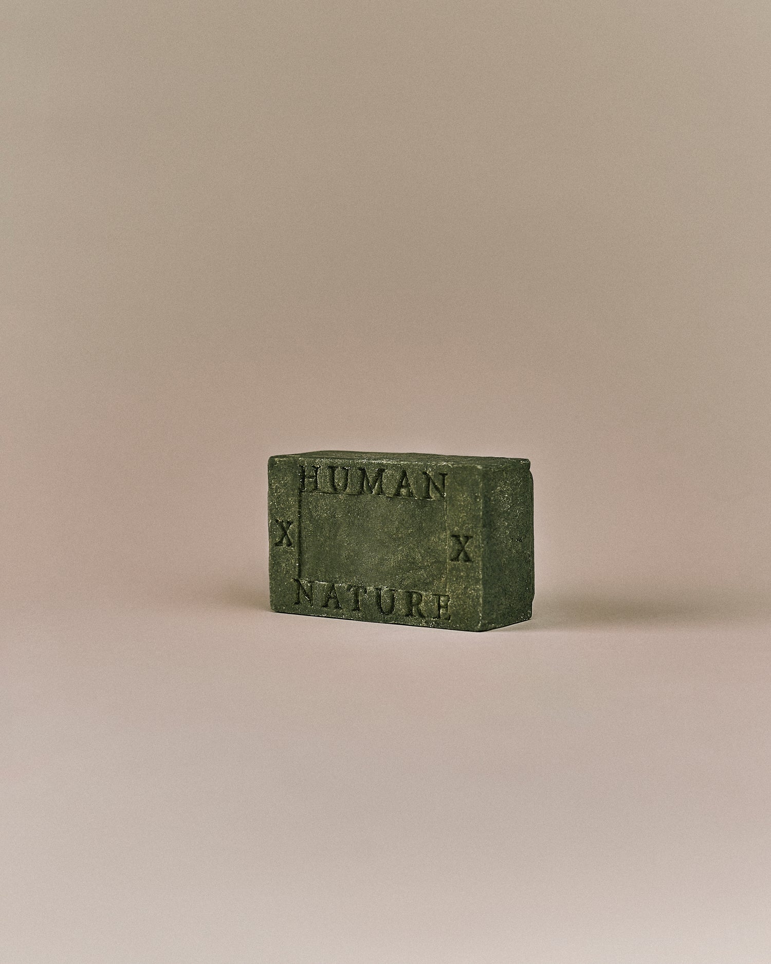 Nhuka Oak Moss One Bar shown at an angle with Human x Nature emboss. Handmade in Australia, pH-balanced, sulfate-free, silicone-free, and organic. Earthy scent with gentle cleansing for hair, face, and body.