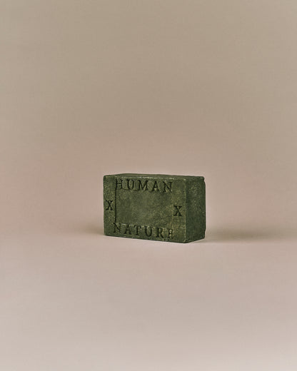 Nhuka Oak Moss One Bar shown at an angle with Human x Nature emboss. Handmade in Australia, pH-balanced, sulfate-free, silicone-free, and organic. Earthy scent with gentle cleansing for hair, face, and body.