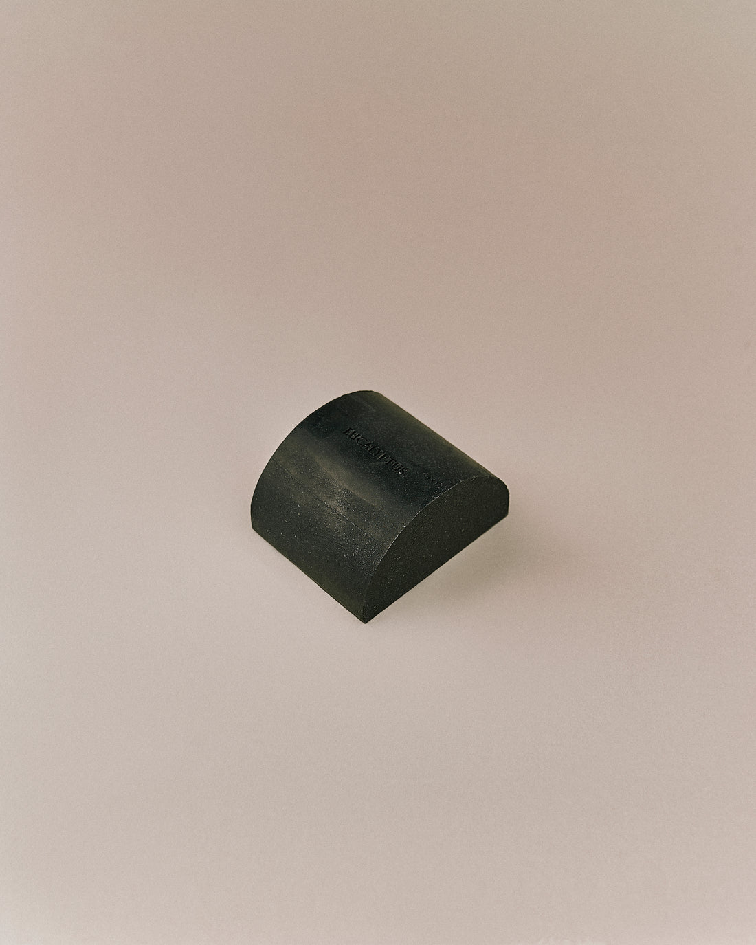 Nhuka organic eucalyptus soap bar shown unwrapped at an angle. Solid bar for face and body, handmade with native botanicals.