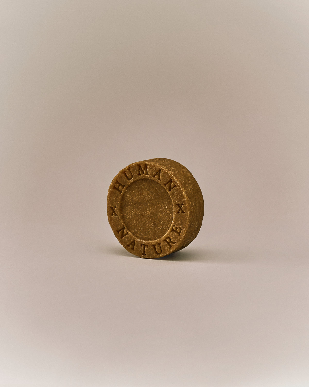 Nhuka organic frankincense shampoo bar shown at an angle with Human x Nature emboss. Handmade in Australia, sulfate-free, silicone-free, pH-balanced for curly, dry, or damaged hair.