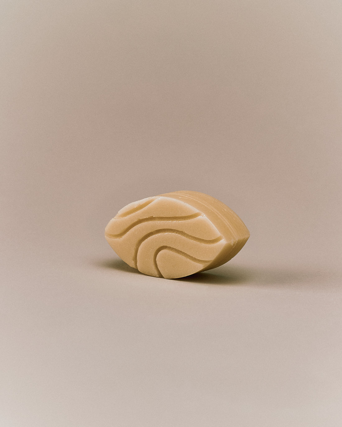 Nhuka organic jasmine conditioner bar shown at an angle with wave-etched design. Handmade in Australia, silicone-free, pH-balanced, and organic — ideal for curly or damaged hair.