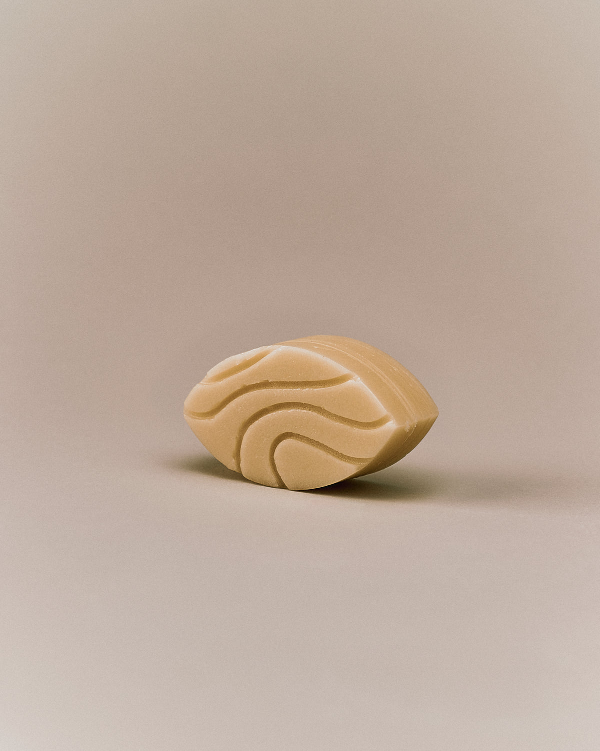 Nhuka organic jasmine conditioner bar shown at an angle with wave-etched design. Handmade in Australia, silicone-free, pH-balanced, and organic — ideal for curly or damaged hair.