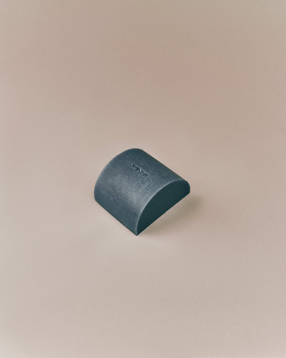 Nhuka organic lavender soap bar shown unwrapped at an angle. Solid cleanser for face and body, infused with hyaluronic acid and macadamia oil.