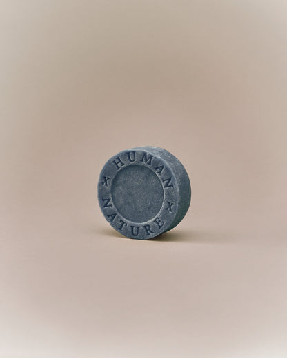 Nhuka organic lavender shampoo bar shown at an angle with Human x Nature emboss. Handmade in Australia, sulfate-free, silicone-free, pH-balanced for dry or frizzy hair.