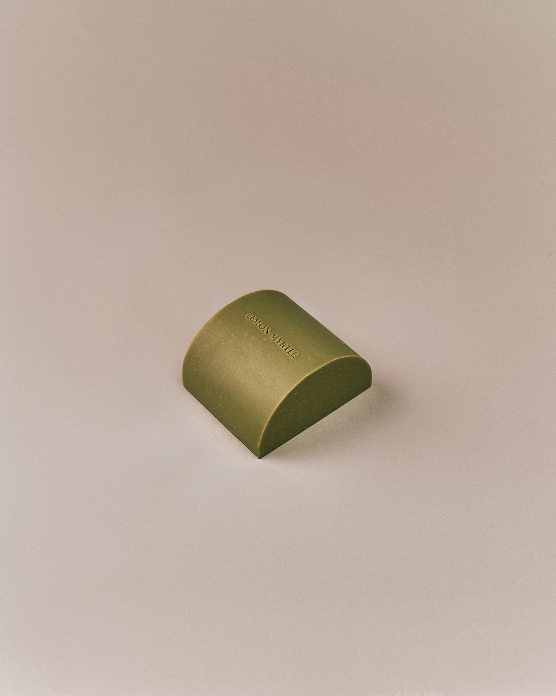 Nhuka organic lemon myrtle soap bar shown at an angle. Solid soap infused with lemon myrtle oil and Brazilian gold clay to soothe and rebalance skin.