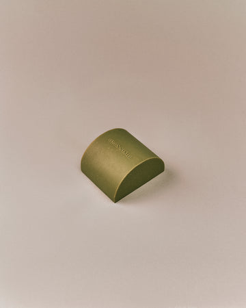 Nhuka organic lemon myrtle soap bar shown at an angle. Solid soap infused with lemon myrtle oil and Brazilian gold clay to soothe and rebalance skin.