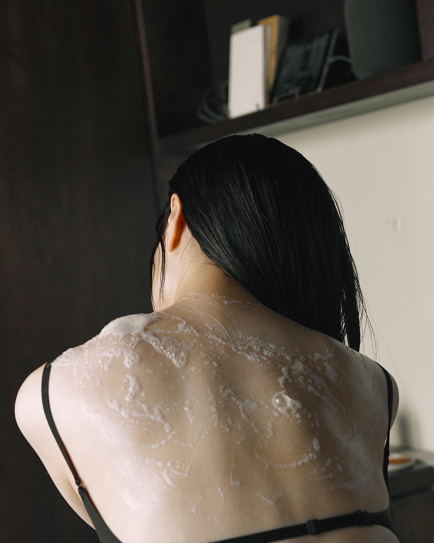 Lathered back and shoulders of model after using Nhuka organic soap. Creamy foam for gentle daily skin care.