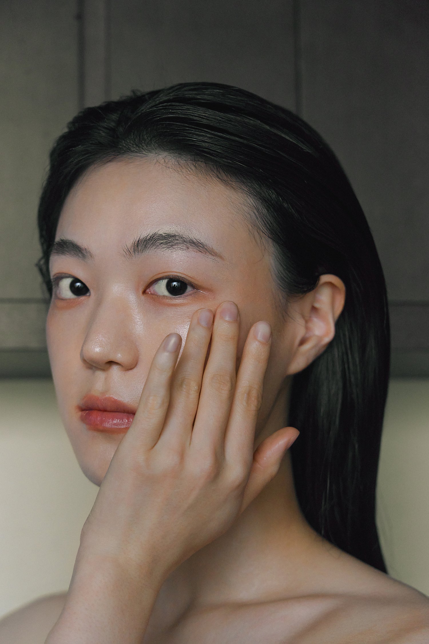 Model massaging Nhuka Restoration Face Serum into skin. Lightweight hydration with ceramides and hempseed oil to soothe irritation and support barrier health.