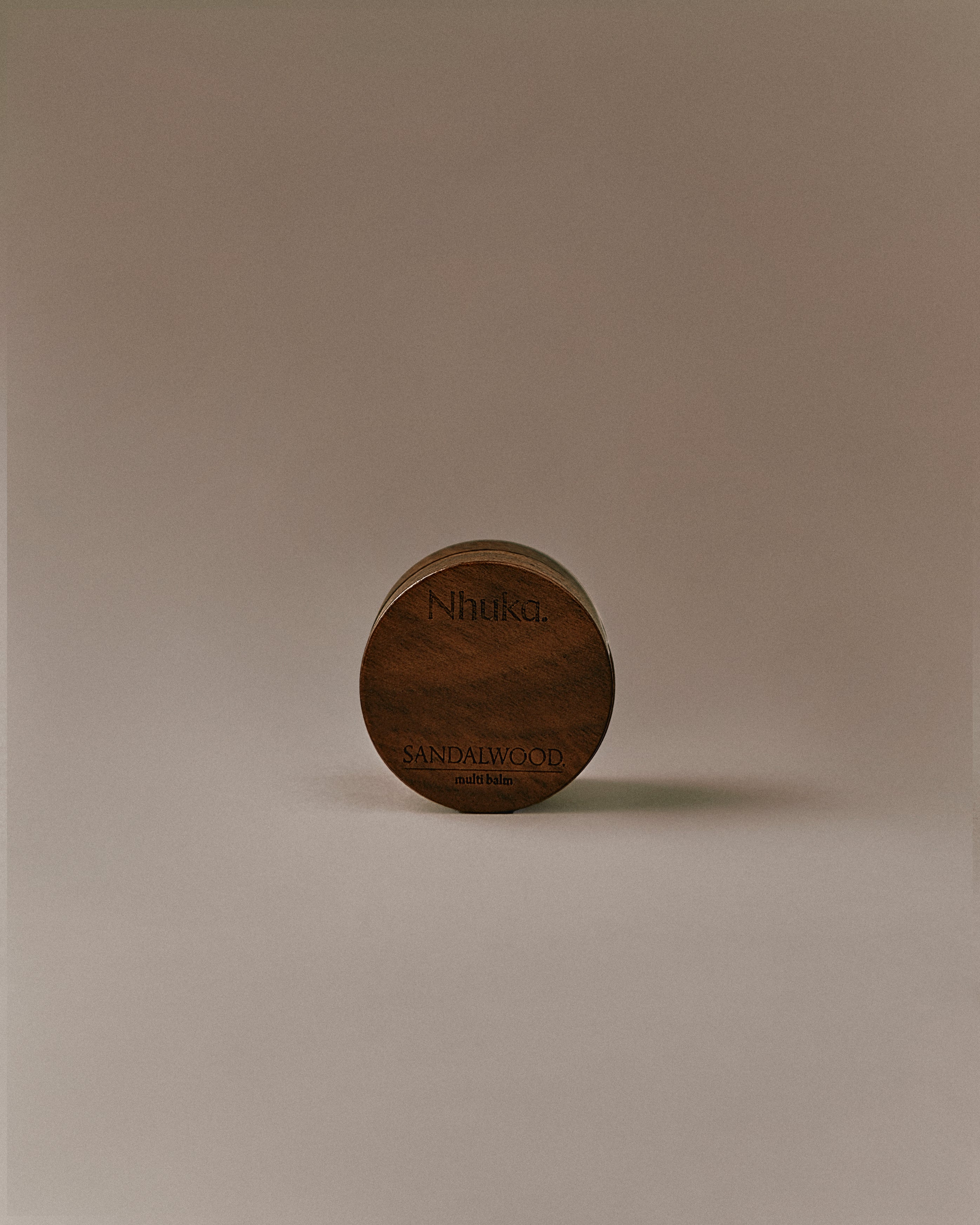 Nhuka Sandalwood Multi Balm shown front on. A velvety-rich balm with organic shea butter, hempseed oil, and beeswax to deeply hydrate and repair dry skin. Earthy, soft scent with subtle herbal notes of sandalwood, sage, and vanilla.